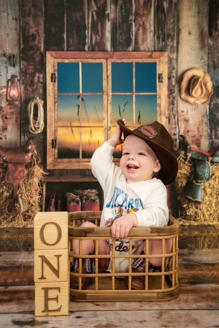 Cake smash birthday session in front of a rustic barn window backdrop